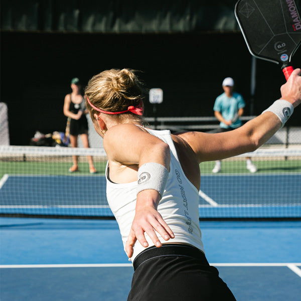 Person playing pickleball on a court with a paddle in hand